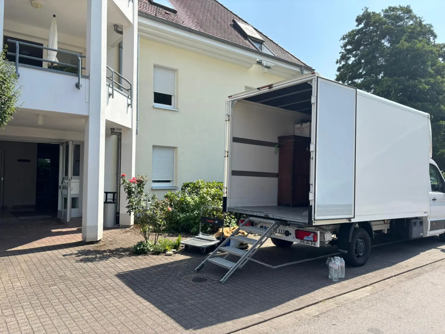 TB Transporte - A transport  truck equipped with a ladder is parked in front of a house. 